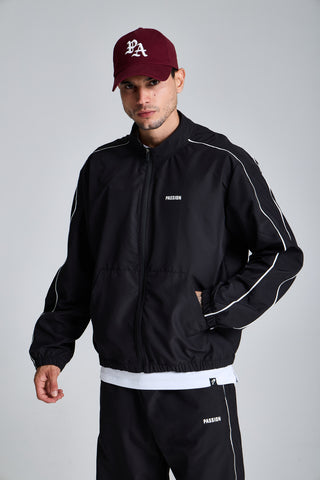 Erkek model üzerinde siyah Piping Track Jacket, önden görünüm; kollarda beyaz biye