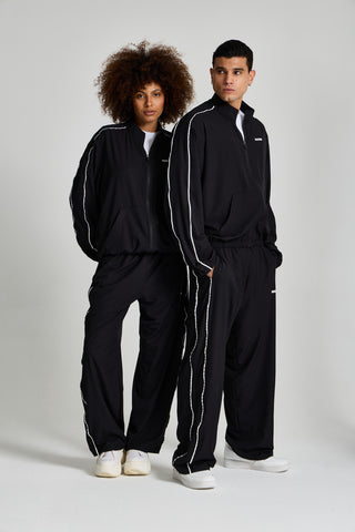 Kadın ve erkek model üzerinde siyah Piping Track Jacket ve Jogger takımı, tam boy görünüm