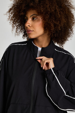 Kadın model üzerinde siyah Piping Track Jacket, dik yaka ve fermuar detayı