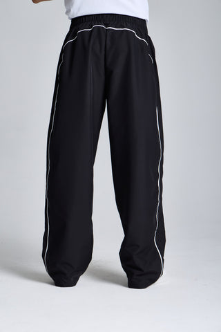 Erkek model üzerinde siyah Piping Track Jogger, arkadan görünüm; geniş paça
