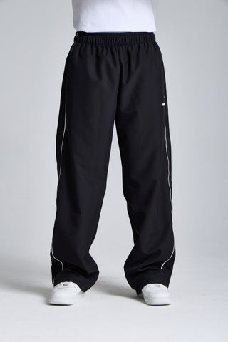 Erkek model üzerinde siyah Piping Track Jogger, önden görünüm; lastikli bel