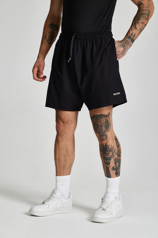 Erkek model üzerinde siyah Basic Performance Short, açılı önden görünüm