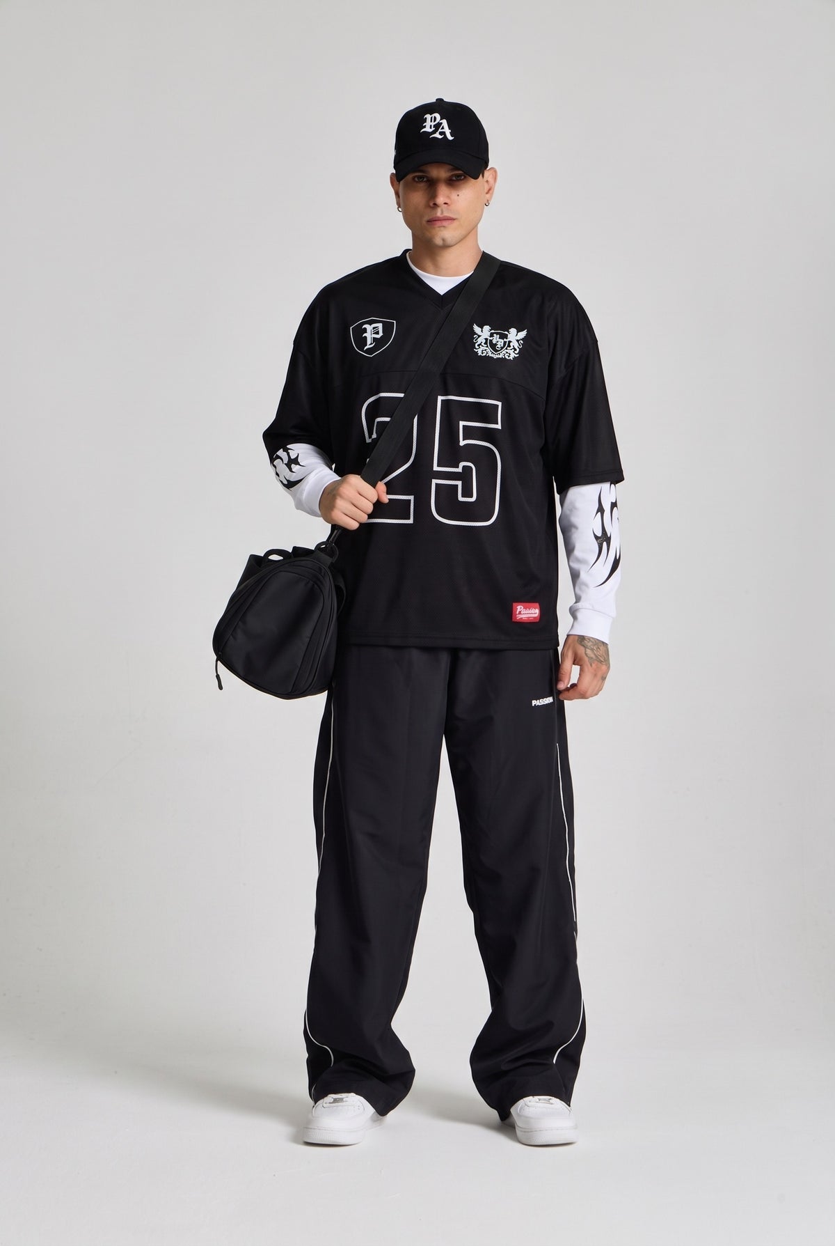 Erkek model üzerinde Varsity Jersey, Inferno Graphic Longsleeve Beyaz, Track Jogger ve P.A Logo Cap kombini