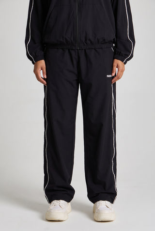 Kadın model üzerinde siyah Piping Track Jogger, önden görünüm; bacakta beyaz biye