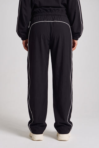 Kadın model üzerinde siyah Piping Track Jogger, arkadan görünüm; geniş paça