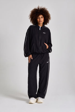 Kadın model üzerinde siyah Piping Track Jogger ve Jacket takımı, önden tam boy görünüm