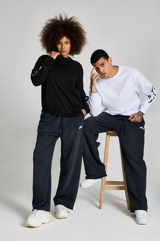 Kadın ve erkek model üzerinde Inferno Graphic Longsleeve; erkek beyaz, kadın siyah, tabure başında tam boy
